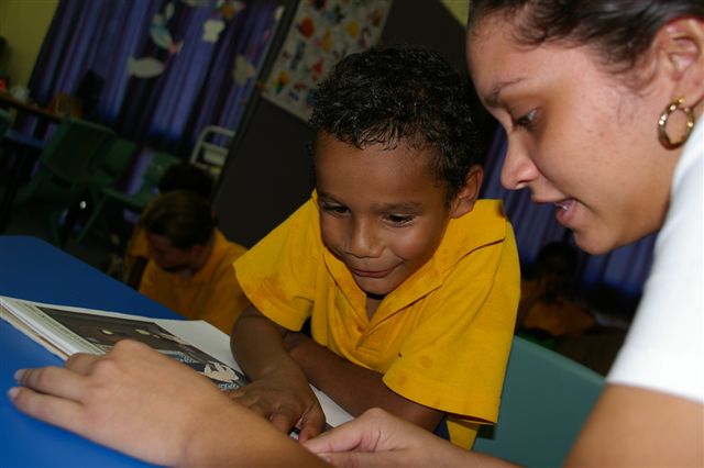 Photo of young aboriginal boy being educated by an aboriginal teacher